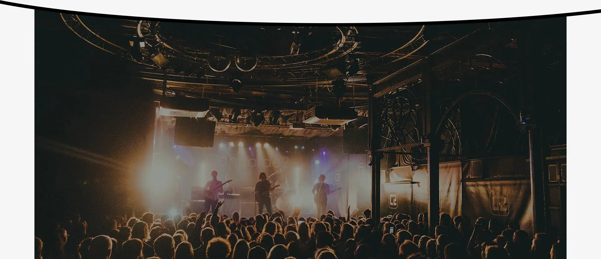 A crowd of people in front of stage lights.