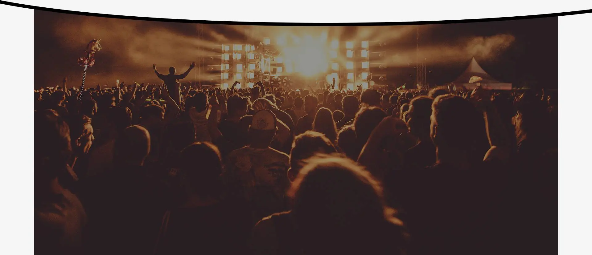 A crowd of people in front of lights at night.