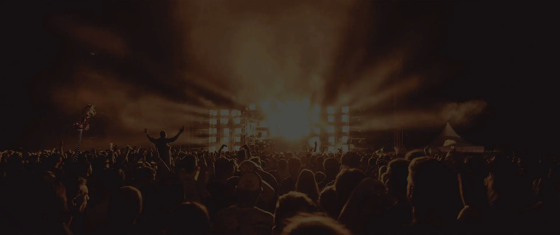 A crowd of people in front of lights at night.